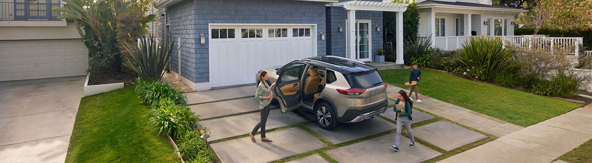 Mom Opening the Car Door of Her Nissan SUV for Her Kids