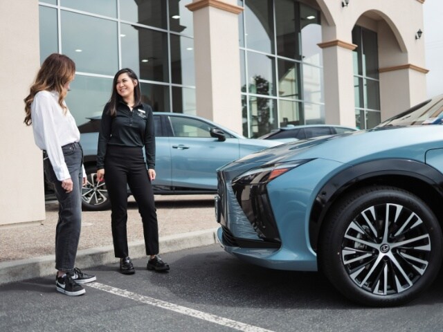 Lexus Serramonte Lexus of Serramonte staff greeting customer near a blue Lexus SUV
