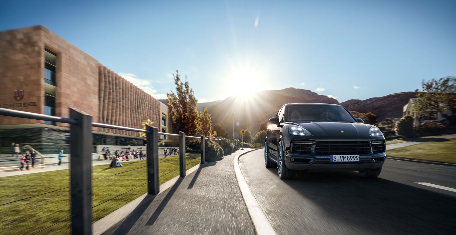 Porsche Cayenne Porsche Cayenne driving by a school
