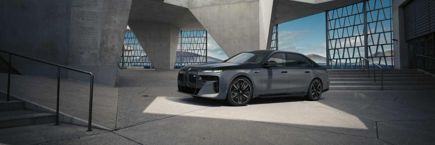 new BMW i7 dark gray BMW i7 sedan parked in an architectural concrete garage