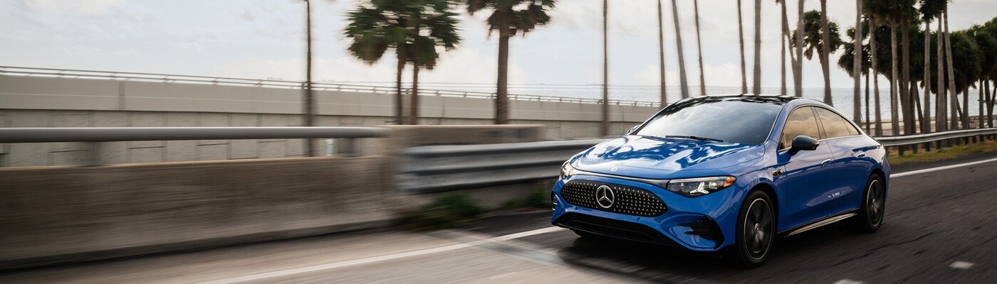 Mercedes-Benz CLA Blue Mercedes-Benz CLA 250+ driving on a highway near the ocean