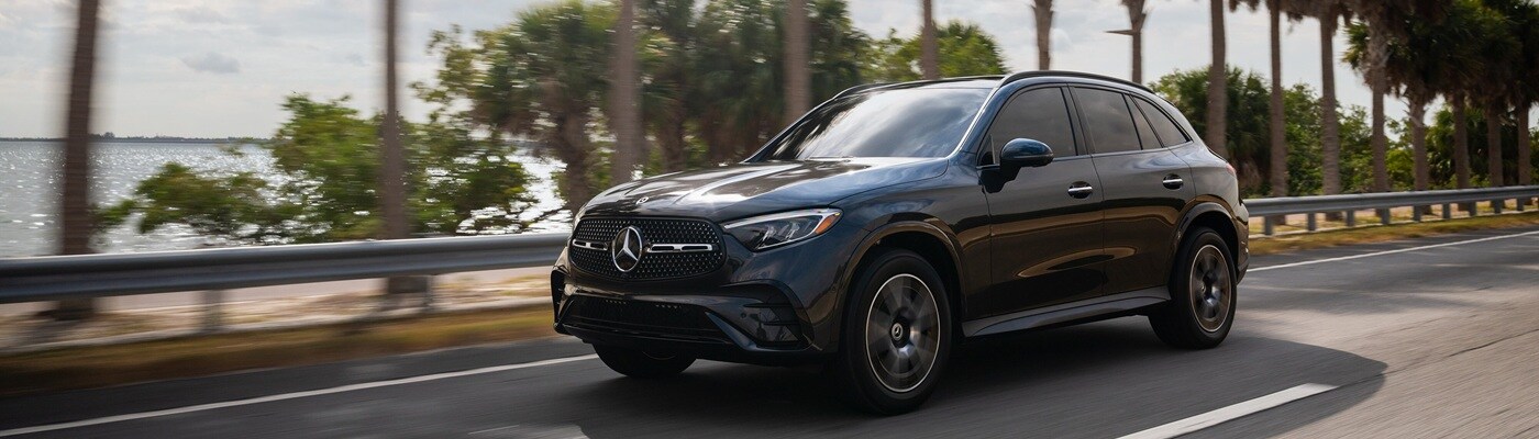 Mercedes-Benz GLC SUV Black Mercedes-Benz GLC SUV driving on a road beside a bay