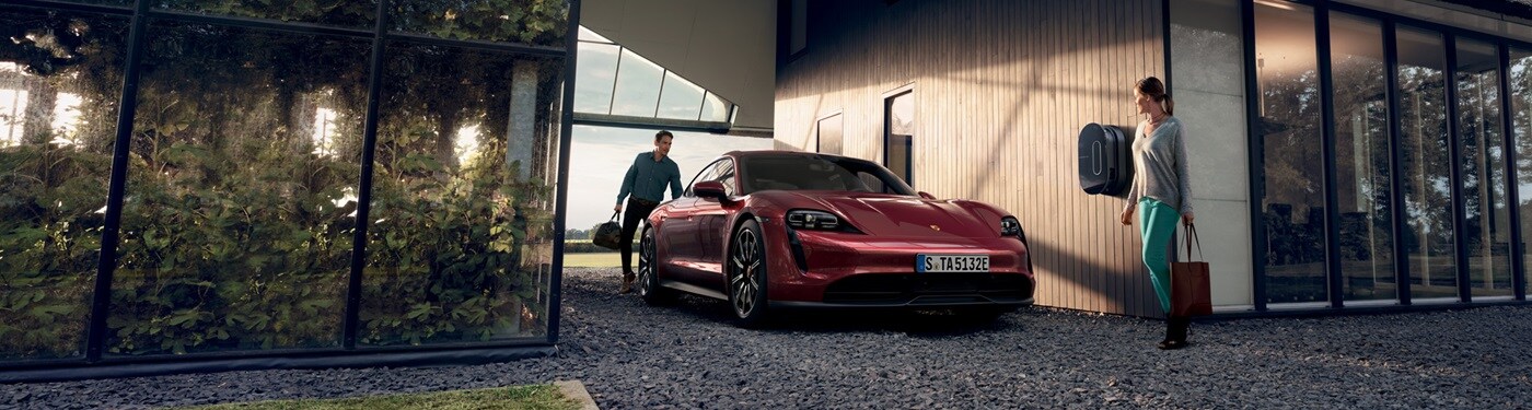 Porsche Taycan Red Taycan parked by a modern house