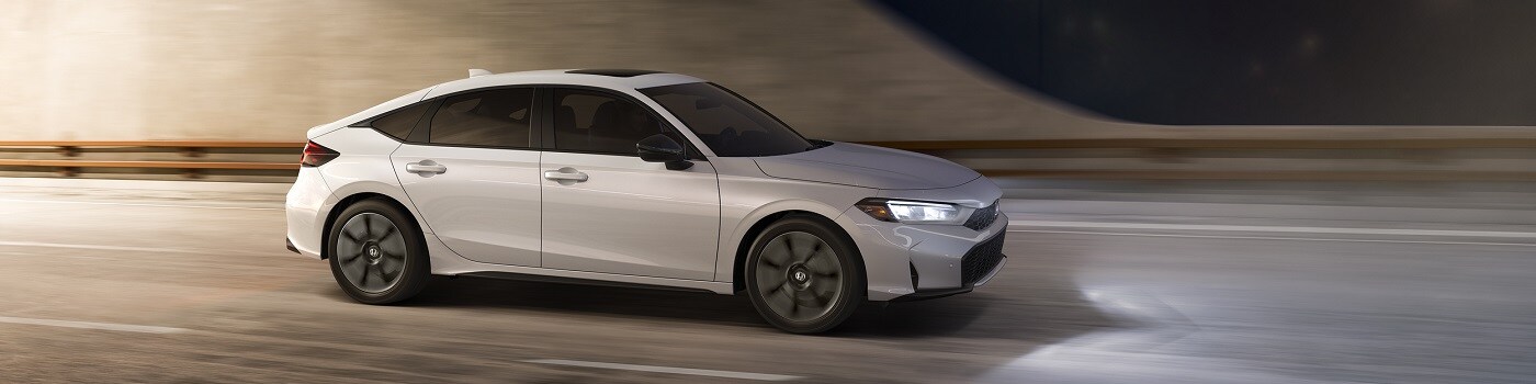 Honda Civic Hatchback Sport Touring Hybrid White Honda Civic Hatchback Sport Touring Hybrid driving thru a city