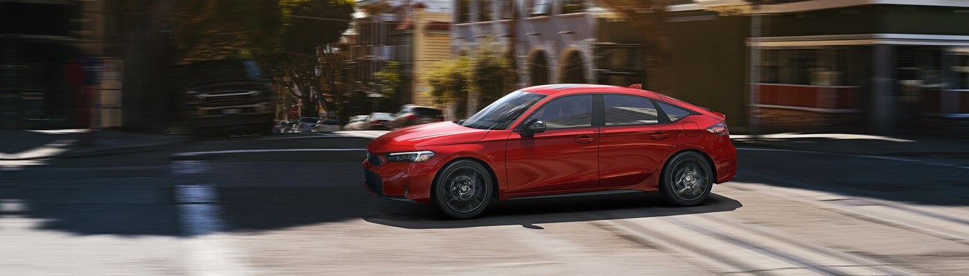Honda Civic Hatchback Sport Hybrid Red Honda Civic Hatchback Sport Hybrid driving thru a city