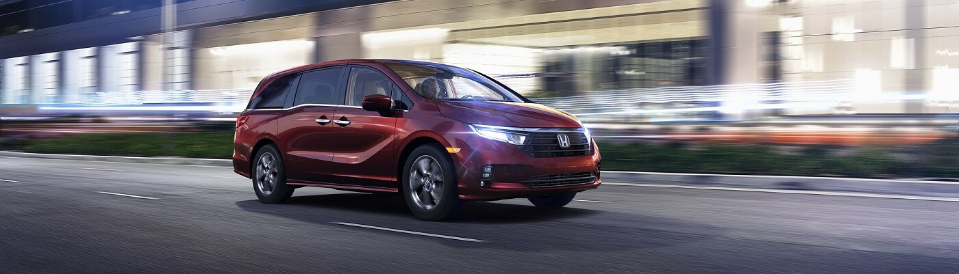 Honda Odyssey Red Honda Odyssey Elite driving in a city at night