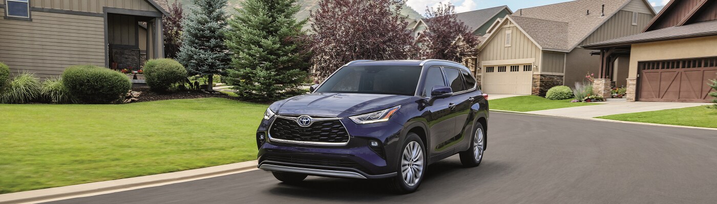 Toyota Highlander Hybrid Platinum Blue Toyota Highlander Hybrid Platinum driving in the suburbs