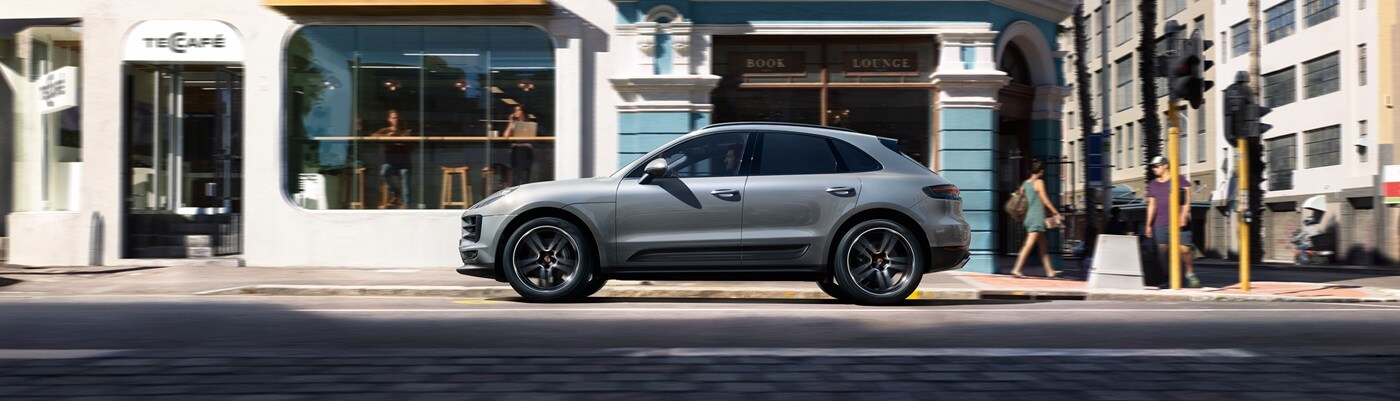 Grey Porsche Macan Base driving on a city street