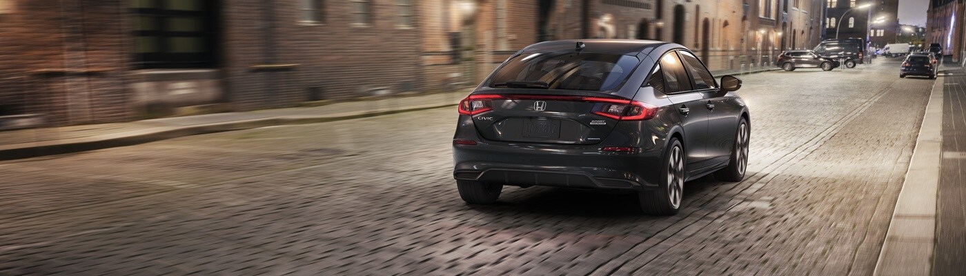 Honda Civic Hatchback Grey Civic Hatchback Sport Touring Hybrid driving in a city
