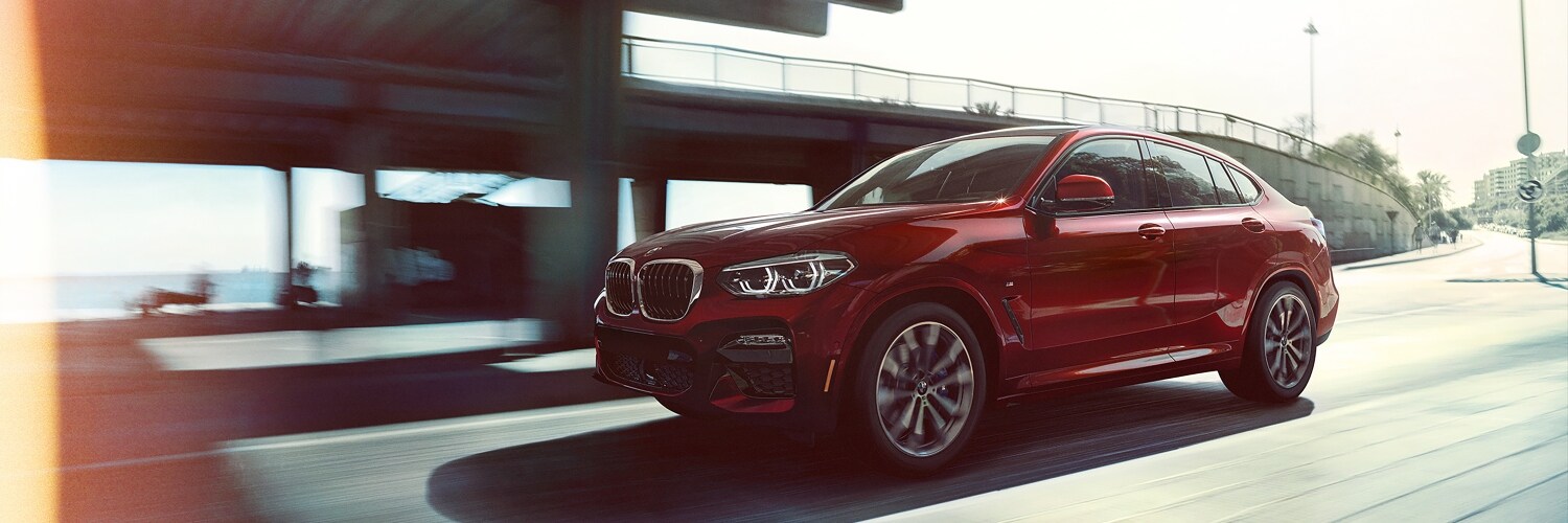 BMW X4 red BMW X4 driving on the road