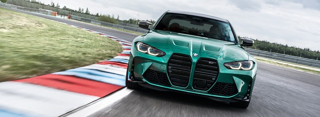 BMW M3 Green BMW M3 sedan driving on a race track