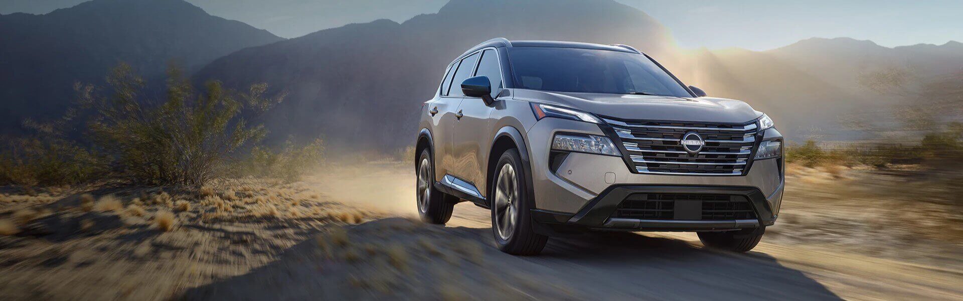 2024 Nissan Rogue Mid-Size Crossover Banner 2024 Nissan Rogue Mid-Size Crossover Driving Through Sandy Road