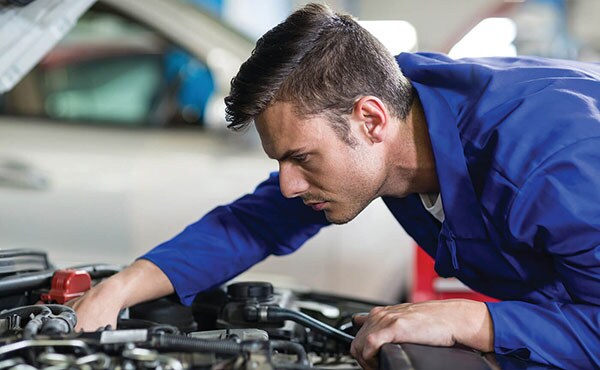 A service mechanic repairing an engine.