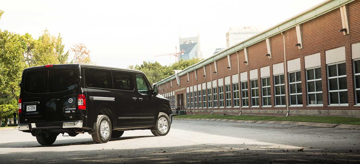 NV Passenger Van in black parked on an empty road.