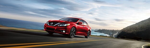 2019 Nissan Altima Blue 2019 Nissan Altima driving down street by ocean
