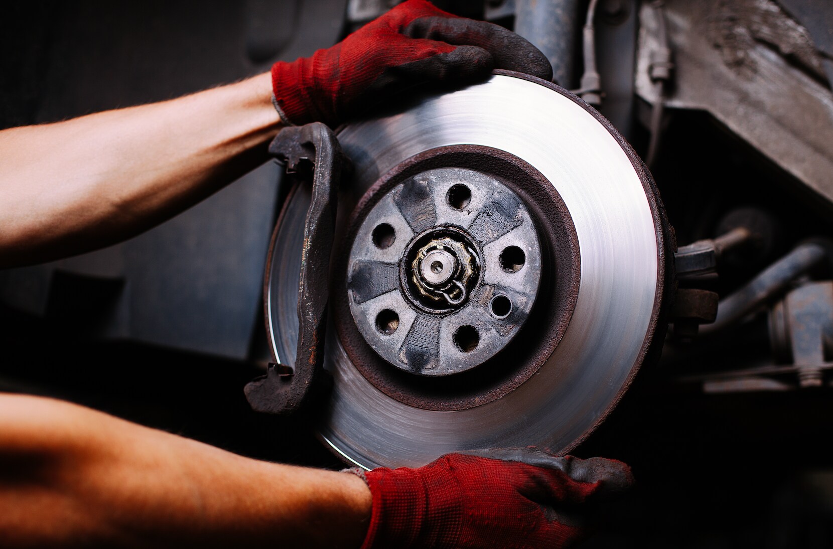Subaru service technician replacing old brakes.