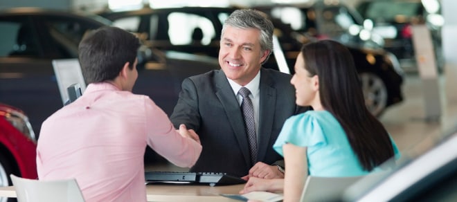 Car Dealer Finance Manager talking with a man and woman.jpg