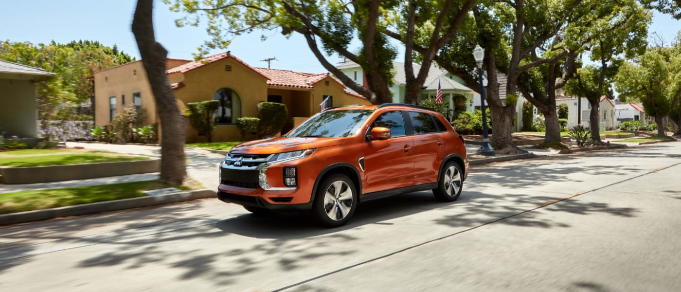 Orange 2020 Mitsubishi Eclipse Cross driving down a street