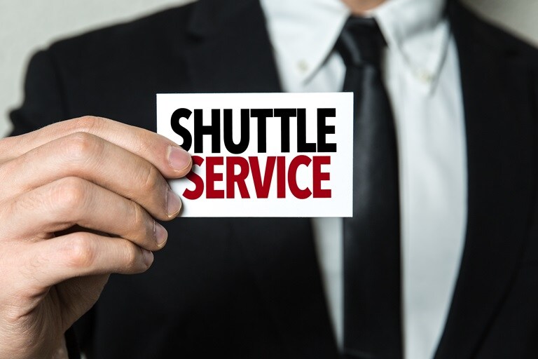 shuttle-service-website.jpeg Man holding shuttle service sign