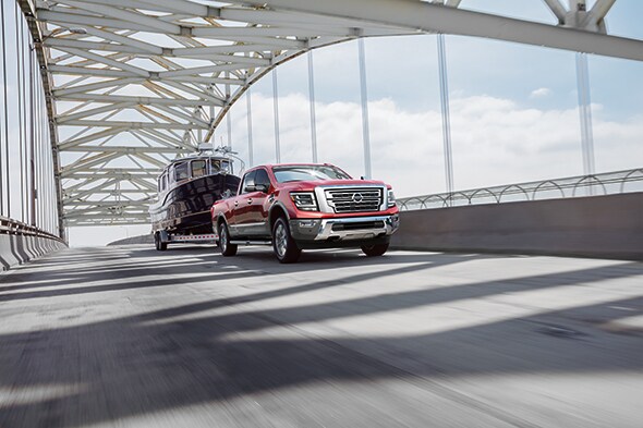 New-2020-Nissan-Titan-XD-Exterior-Driving-Towing.jpg New 2020 Nissan Titan XD driving over a bridge towing a boat