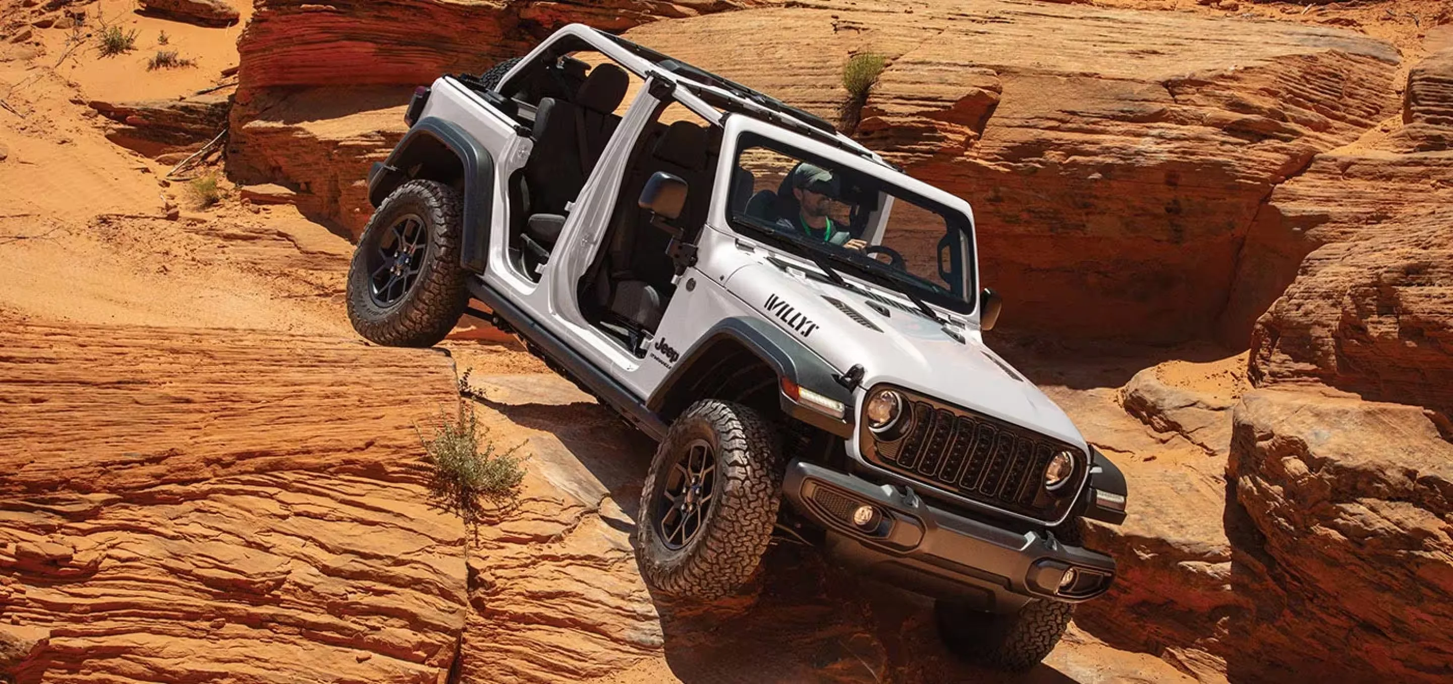 A white 2026 Jeep Wrangler Willys four door with the doors and top removed, at Sport Durst CDJR in Durham, NC