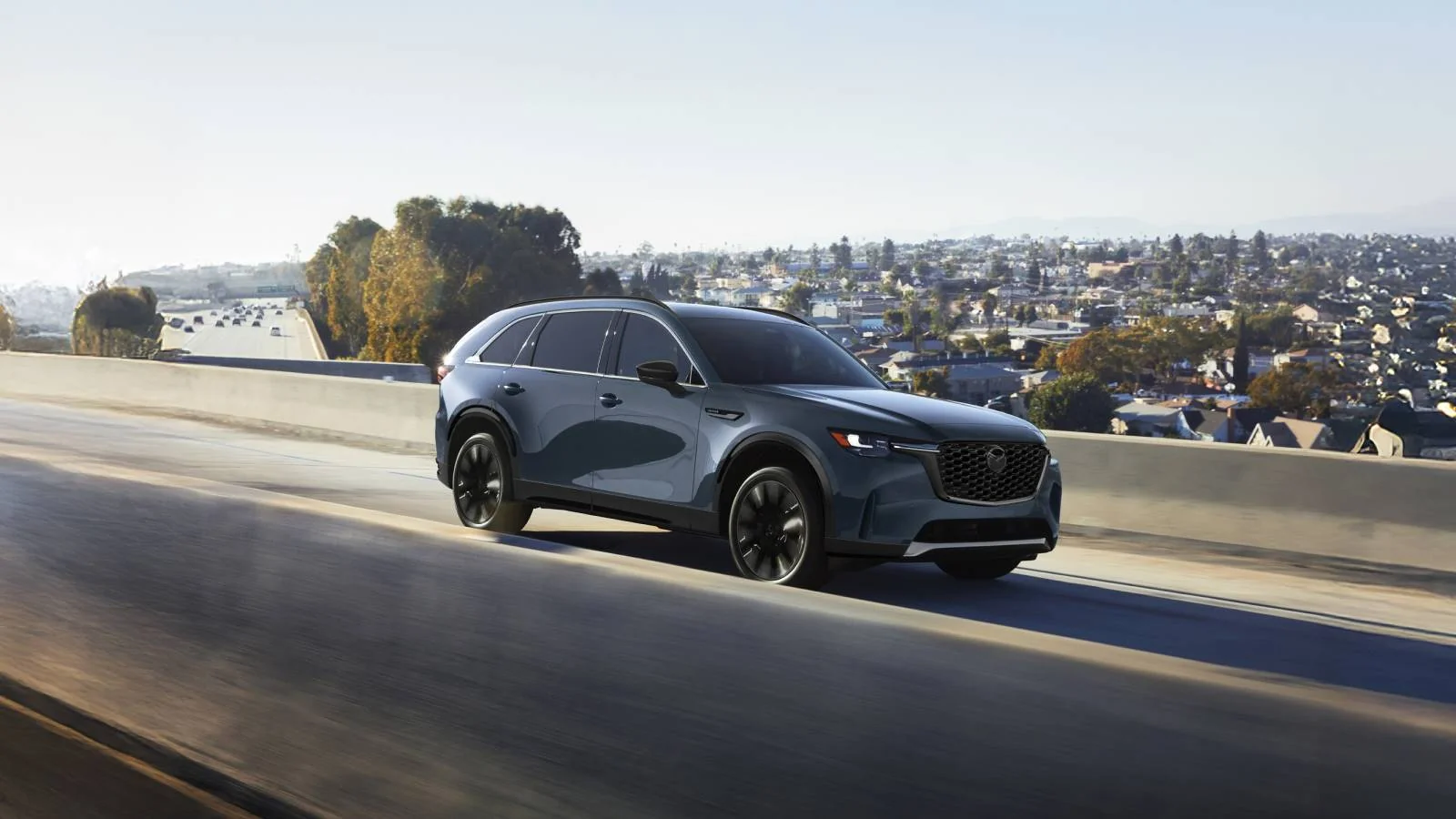 2026 Mazda CX-90 driving on an elevated highway, three-row SUV near Goldsboro, NC