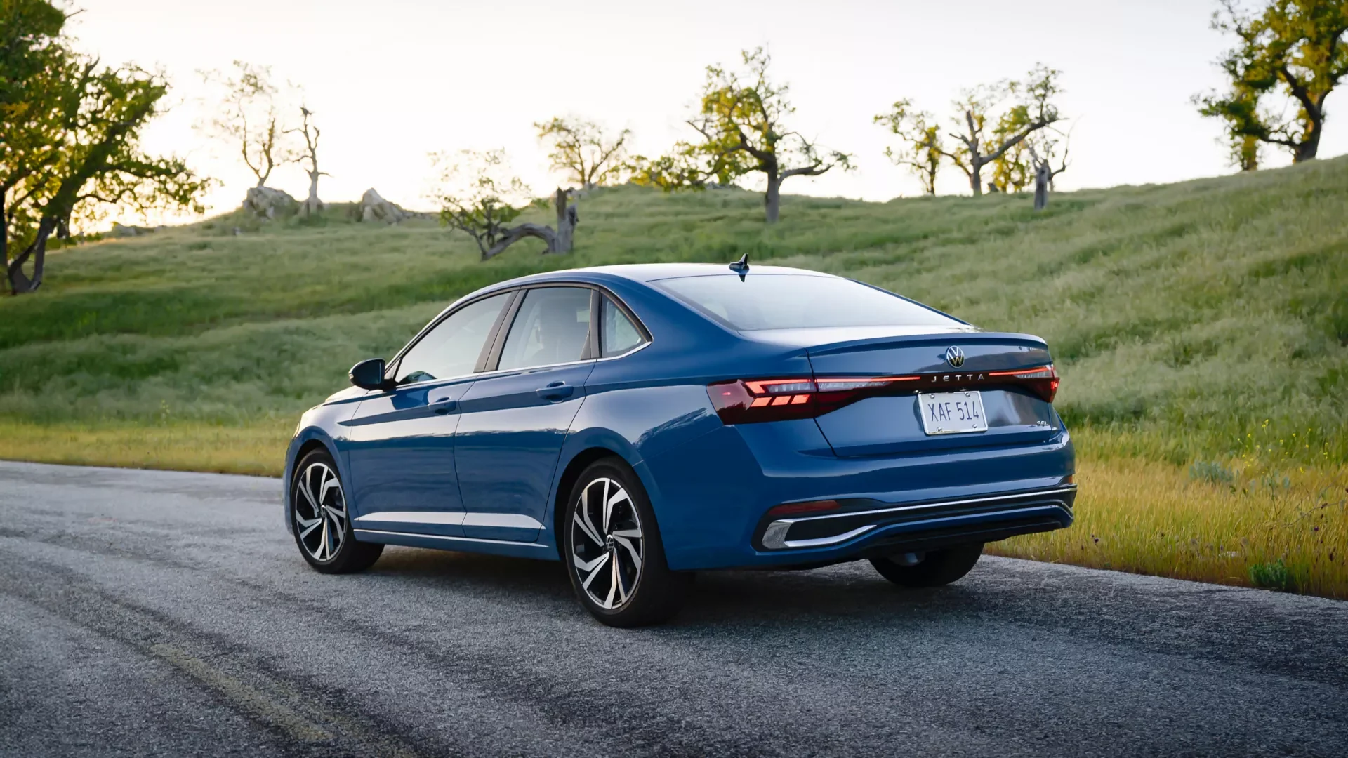 2026 Volkswagen Jetta rear three quarter view in blue on an open road, available to test drive in Jacksonville NC