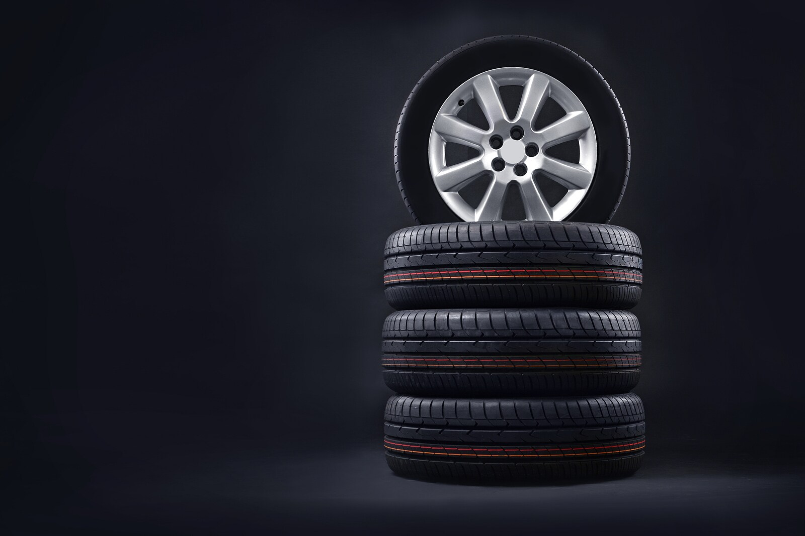 bigstock-New-Tires-Pile-On-A-Dark-Backg-311494078.jpg