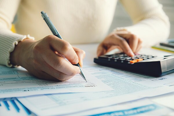 close up of a hands filling out tax forms