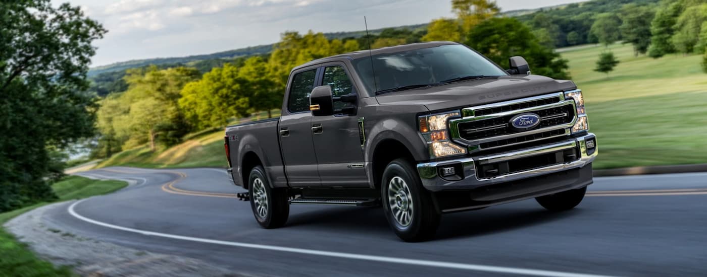 Grey 2021 Ford F-250 Super Duty driving down a winding road from a used Ford dealer near Trenton.