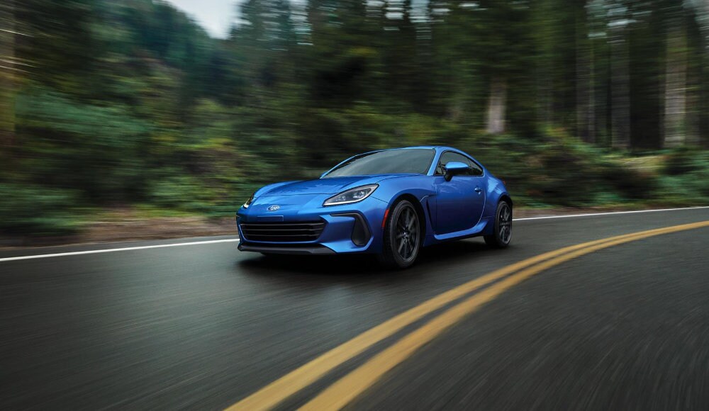 vue latérale avant d'un Subaru BRZ 2023 sur une route en forêt