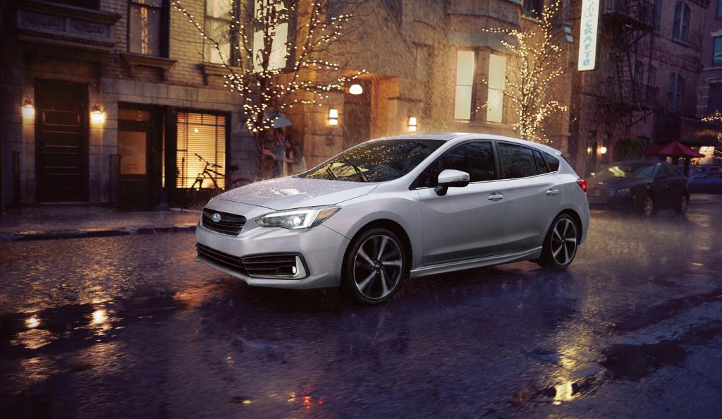 vue latérale avant d'une Subaru Impreza 2023 sur une rue un soir de pluie