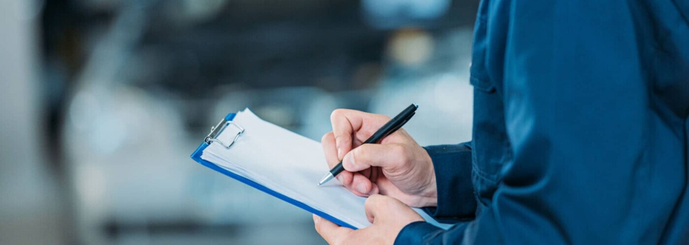 Mechanic hands writing on clipboard