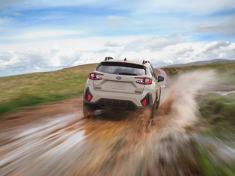 New Subaru Crosstrek Hybrid pictured on a muddy road. New Subaru Crosstrek Hybrid can handle wet or muddy roads.