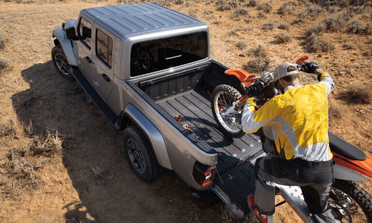 man loadin a motorbike on a 2020 Jeep Gladiator