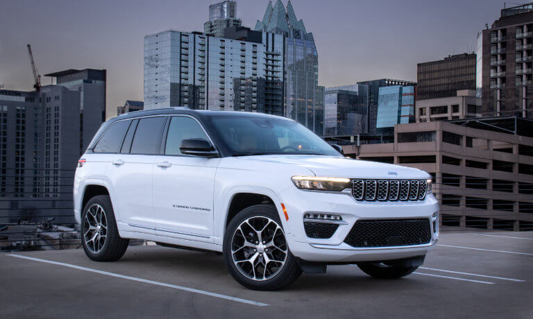 2025 Jeep Grand Cherokee parked in front of city skyline