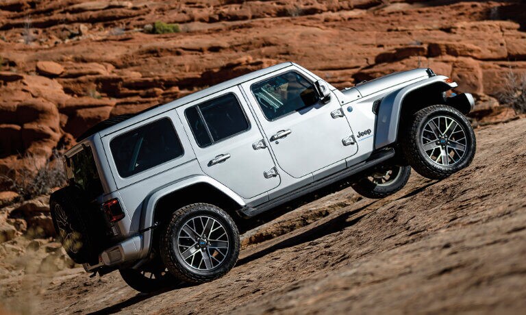 2025 Jeep Wrangler 4xe driving on a rocky incline