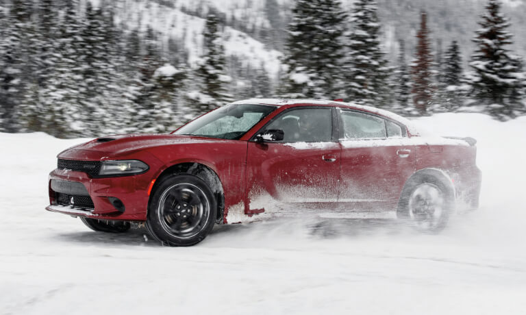 2023 Dodge Charger driving through a snowy forest