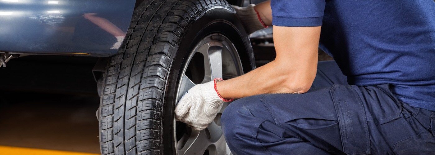Technician Changing Tire in Shop