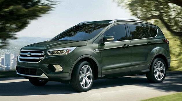 Ford Escape Green 2019 Ford Escape driving through a park with a cityscape background