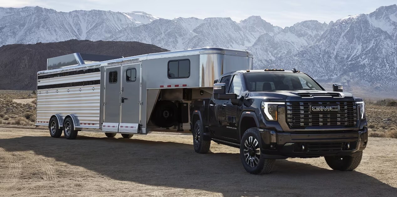 2024 GMC Sierra towing a trailer on a dirt road 2024 GMC Sierra towing a trailer on a dirt road