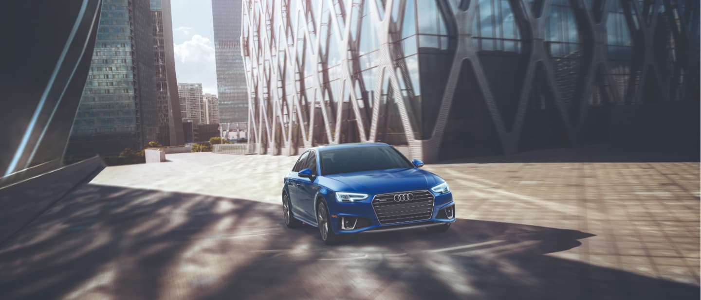 2019 Blue Audi A4 Driving Past a Building