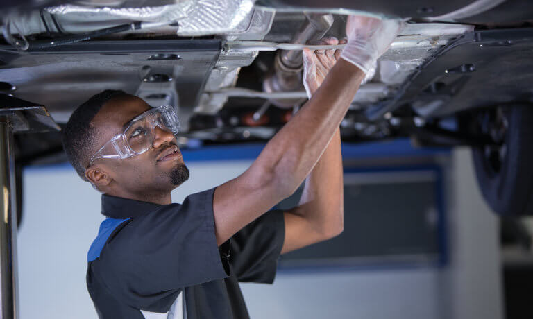 VW technician working under vehicle