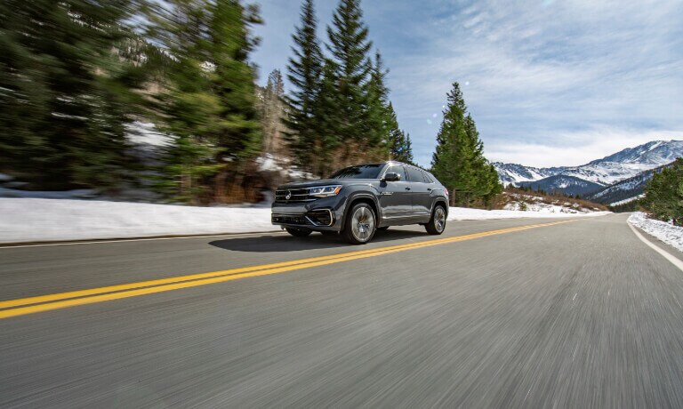 2022 VW Atlas Cross Sport driving down a forested mountain road