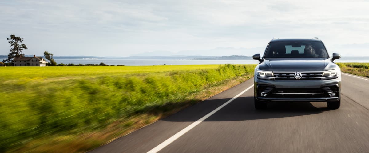 2019 VW Tiguan A black 2019 VW Tiguan driving down an open road