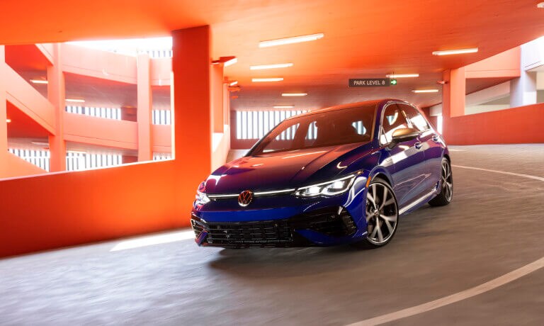 2022 VW Golf GTI driving in an orange parking garage