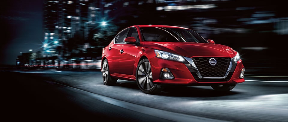 2019 Altima A red 2019 Altima driving on a dark city street