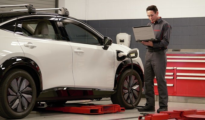 Nissan service team member working with electric vehicle