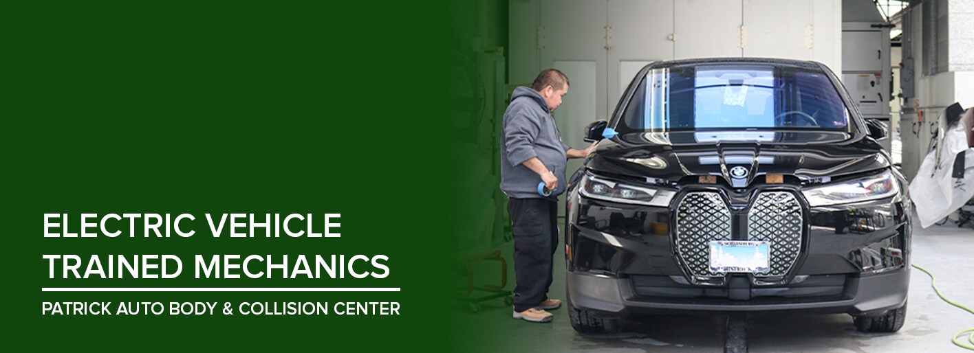 Mechanic working on a black electric BMW inside Patrick Auto Body & Collision Center in Schaumburg and Naperville, IL