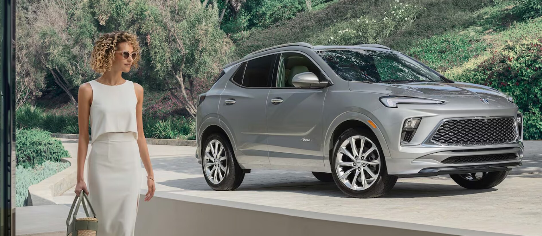 woman standing in front of a new buick woman standing in front of a new buick